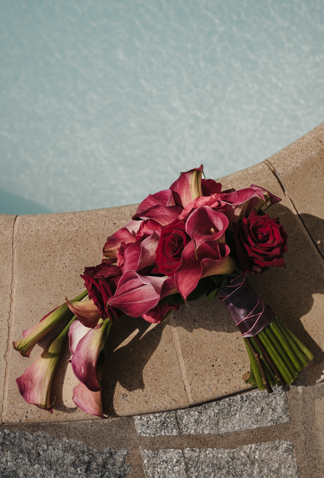 Dunkelroter Brautstrauß am Pool einer Hochzeit in der Toskana