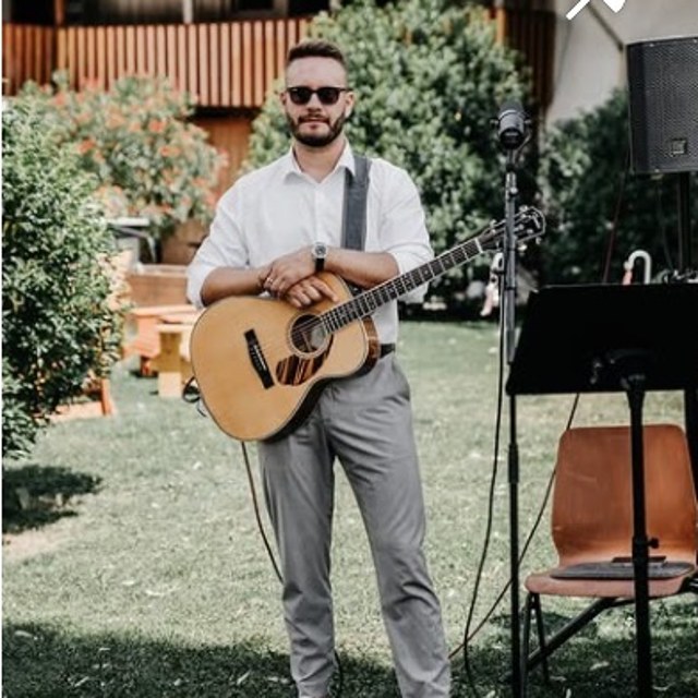 Dennis Ross mit Akustikgitarre vor dem Auftritt